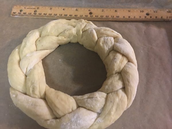 Dough braided and shaped into a plump crown, on its way to becoming King Cake!