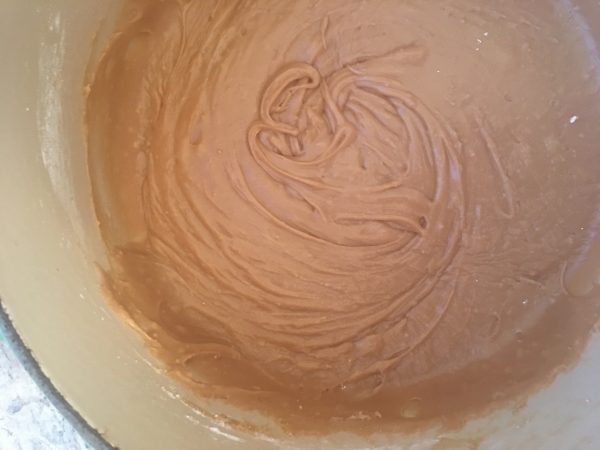 Brown Sugar Glaze in the cooking pot which is a 2-quart enamel cast iron pot; glaze is thick and fudgy, ready to spread on cake. 